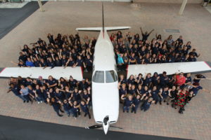 Piper Aircraft employees standing next to an aircraft