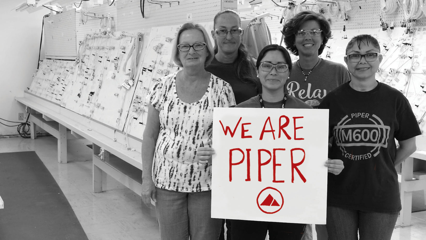 Piper employees holding a sign that says "We are Piper"