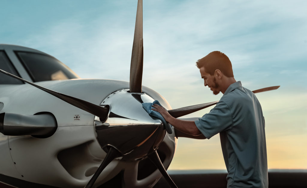 Man wiping the nose of a Piper Aircraft