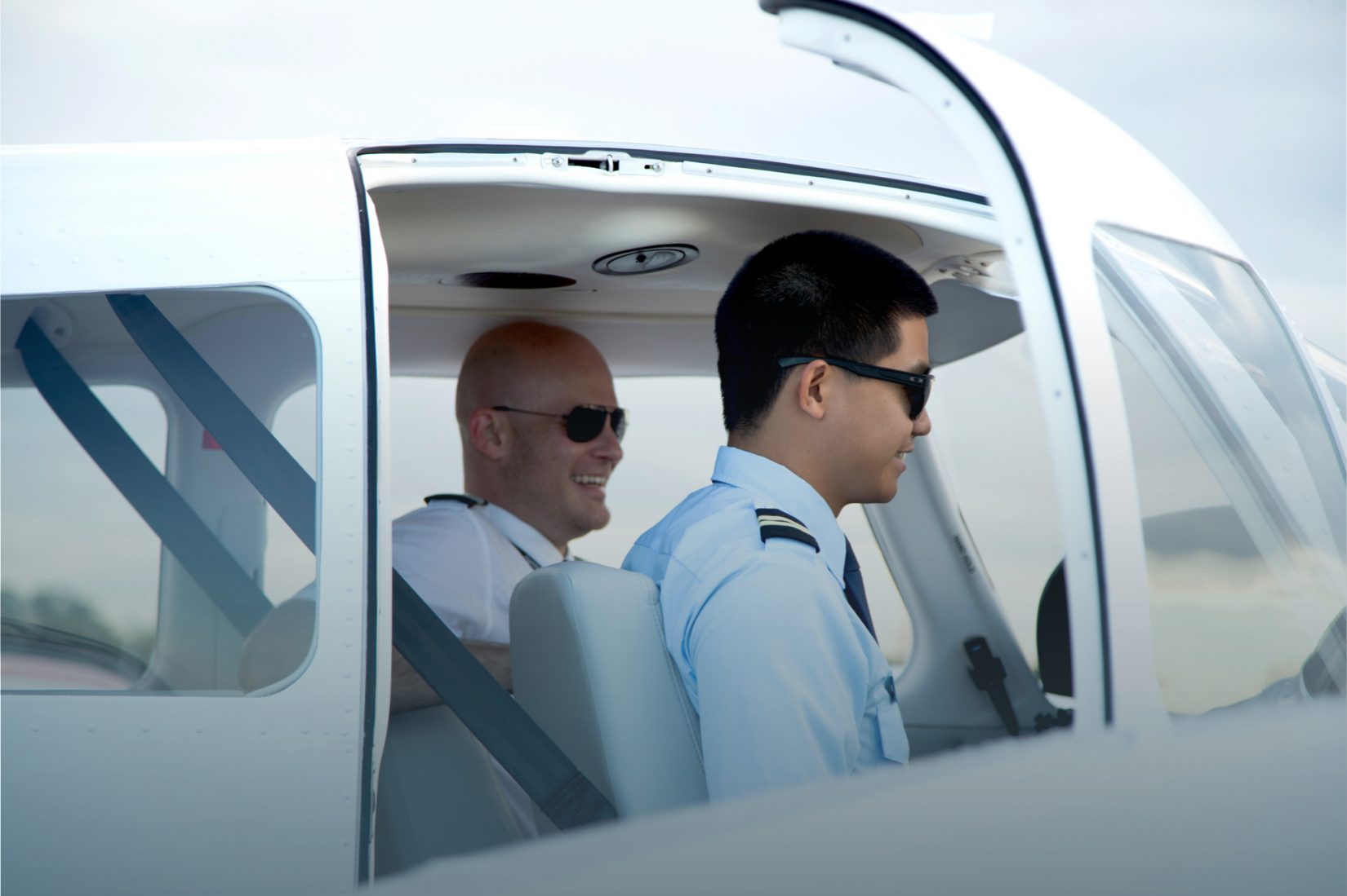 Pilot sitting in cockpit with student pilot