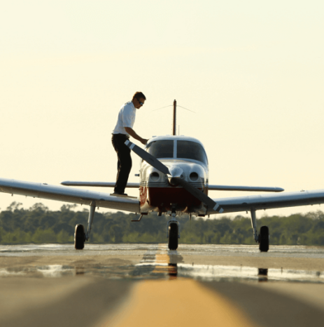 A pilot preparing a Piper aircraft for takeoff