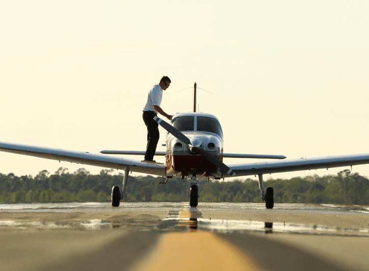 A pilot preparing a Piper aircraft for takeoff