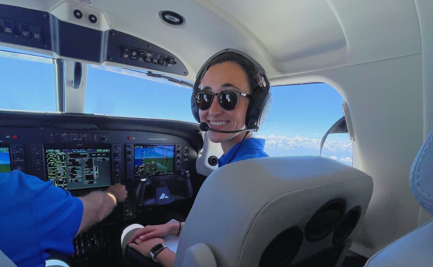 Paige Bishop, a Piper Intern, in the cockpit of a Piper aircraft.