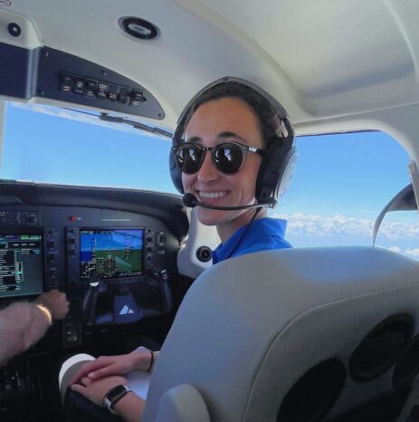 Paige Bishop, a Piper Intern, in the cockpit of a Piper aircraft.