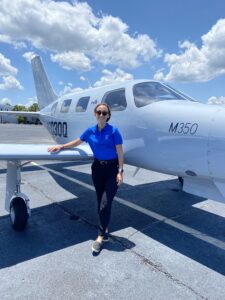 Piper Intern Paige Bishop posing in front of a Piper M350.