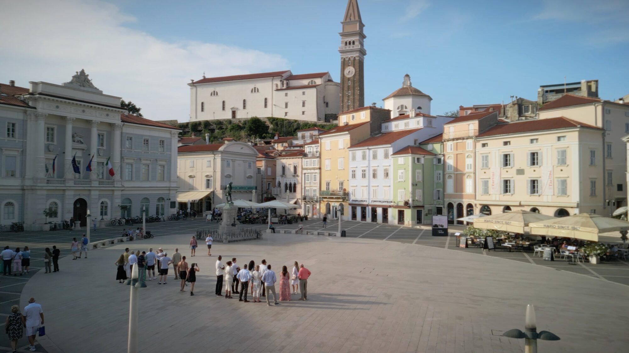 Piper Fly-In guests explore Tartini Square in Piran, Slovenia, surrounded by historic pastel-colored buildings and the town’s clocktower.