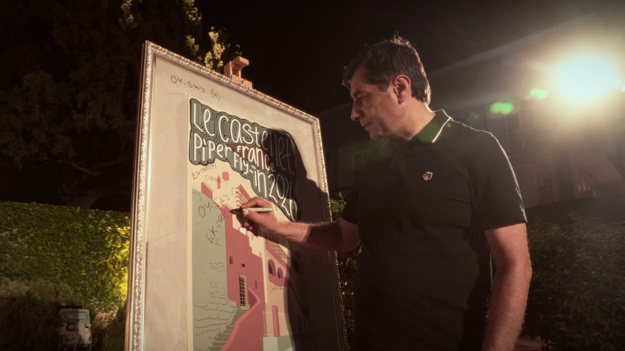 Attendee signs a large framed event poster during the Piper European Fly-In evening gathering.