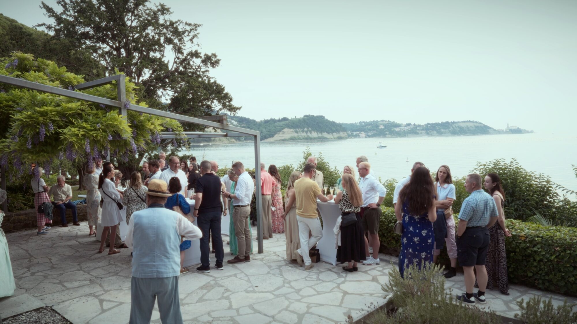 Guests gather on a stone terrace overlooking the sea during the Piper European Fly-In welcome reception in Portorož, Slovenia.
