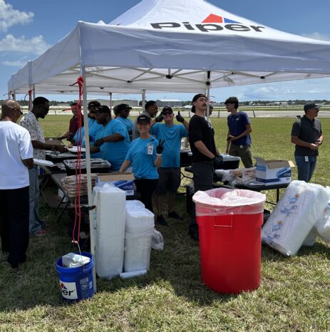 Piper Aircraft team members serve lunch to employees under a branded Piper tent on the airfield during Vero Beach Air Show practice.